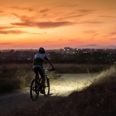 night mtb rider with a light at sunset